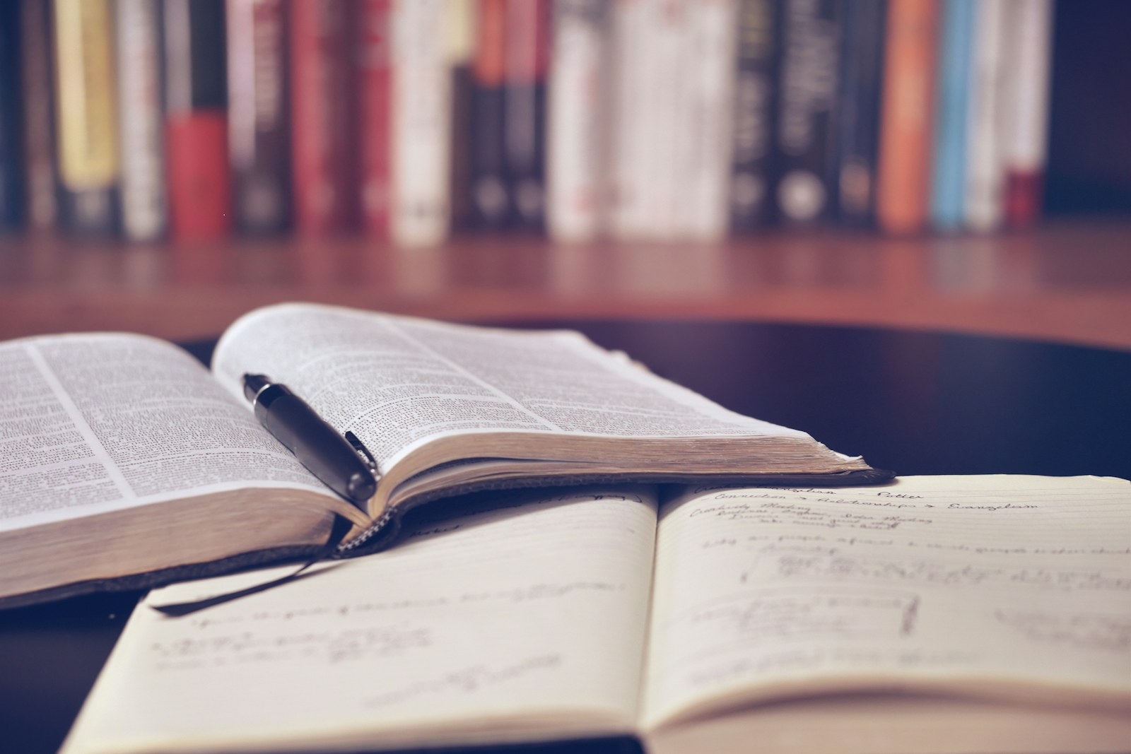 A desk lamp illuminating handwritten pages and an envelope